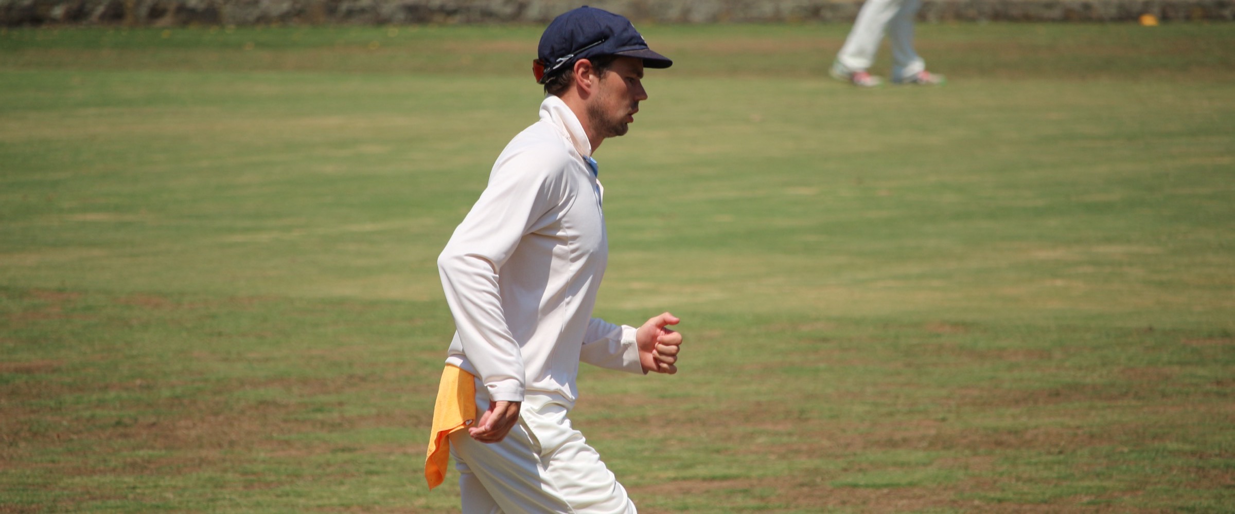 A Canterbury fielder walks in with the bowler at Canterbury Sports Ground, a towel tucked into his waistband